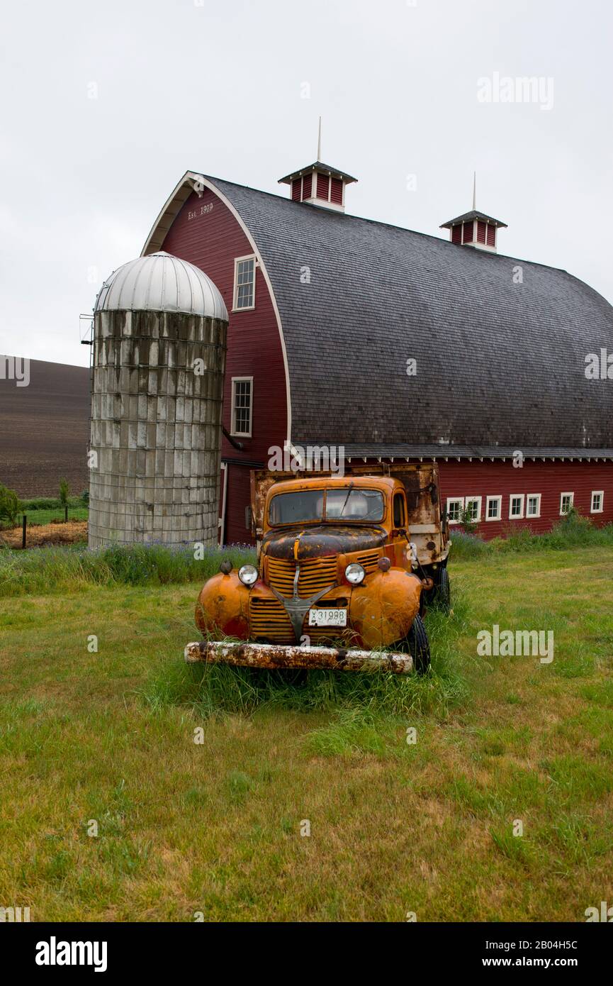 Vecchio camion di fronte al fienile rosso nel Palouse vicino a Colfax, Stato orientale di Washington, Stati Uniti. Foto Stock