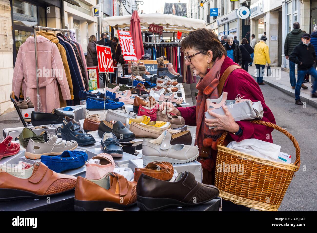 Donna che fa shopping per le scarpe sul mercato all'aperto, Loches, Indre-et-Loire, Francia. Foto Stock