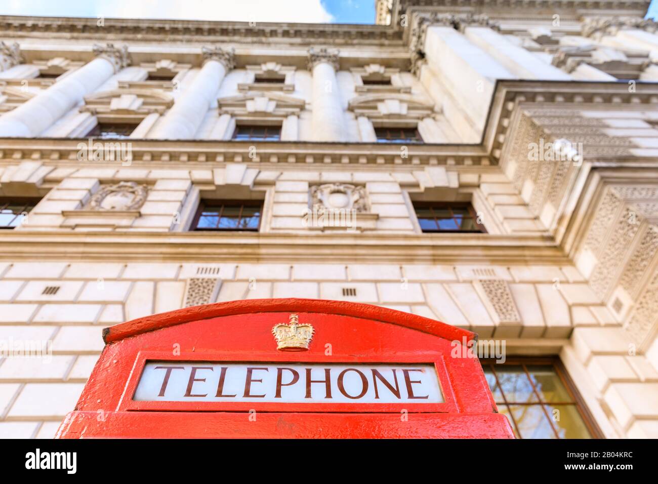 Top of iconic British red telefono box contro edifici storici a Westminster, Londra, Inghilterra, Regno Unito Foto Stock