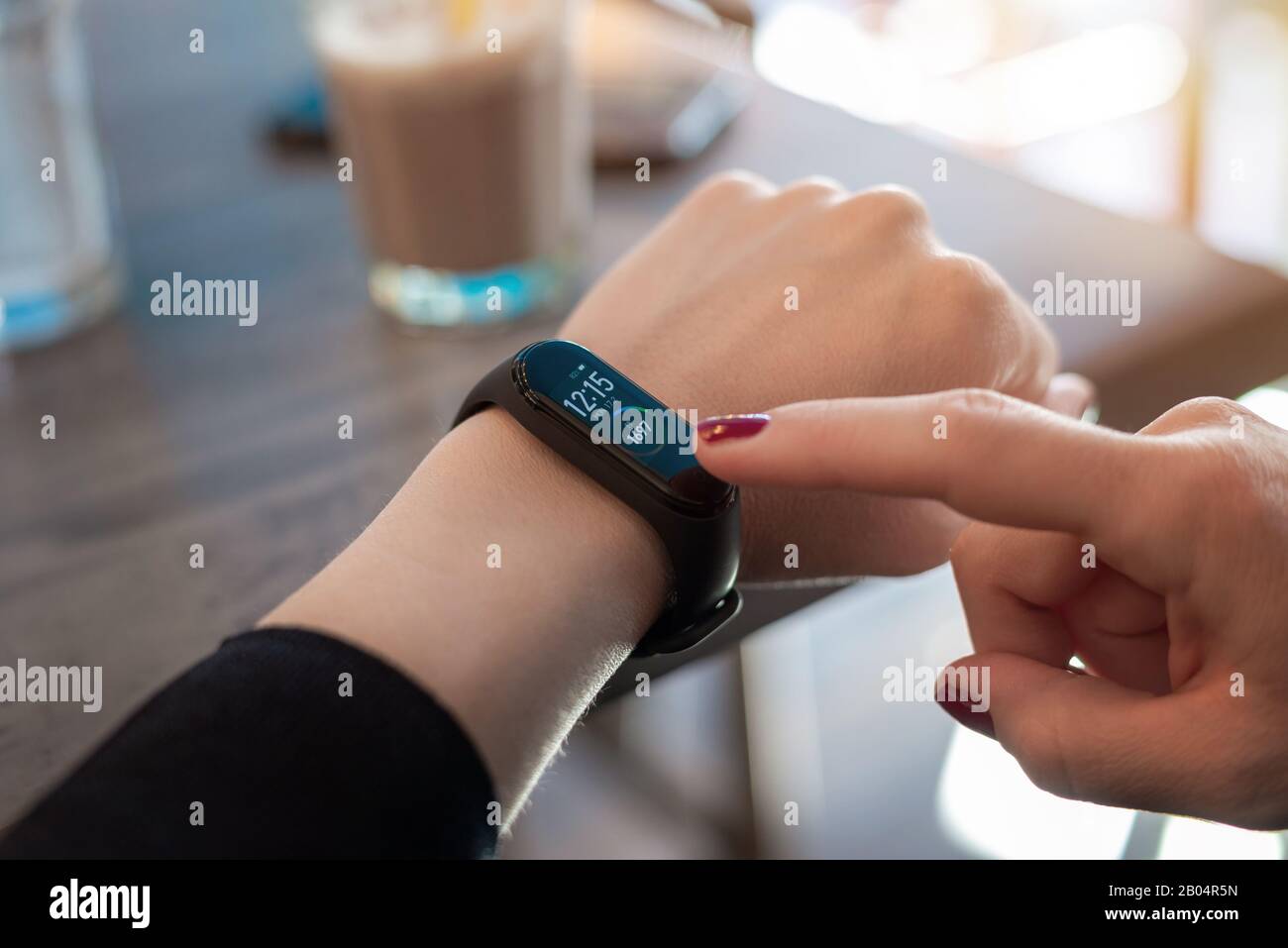Donna usa le app su un braccialetto intelligente. Display Tocuh con lato destro Foto Stock