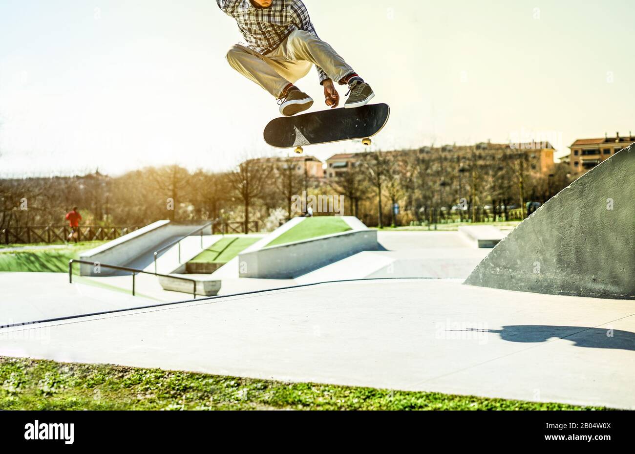Giovane skater che esegue trucchi freestyle nel parco della città - ragazzo  Alla Moda che salta con skateboard all'aperto - concetto di sport estremo -  Focus on man,shoes,board Foto stock - Alamy