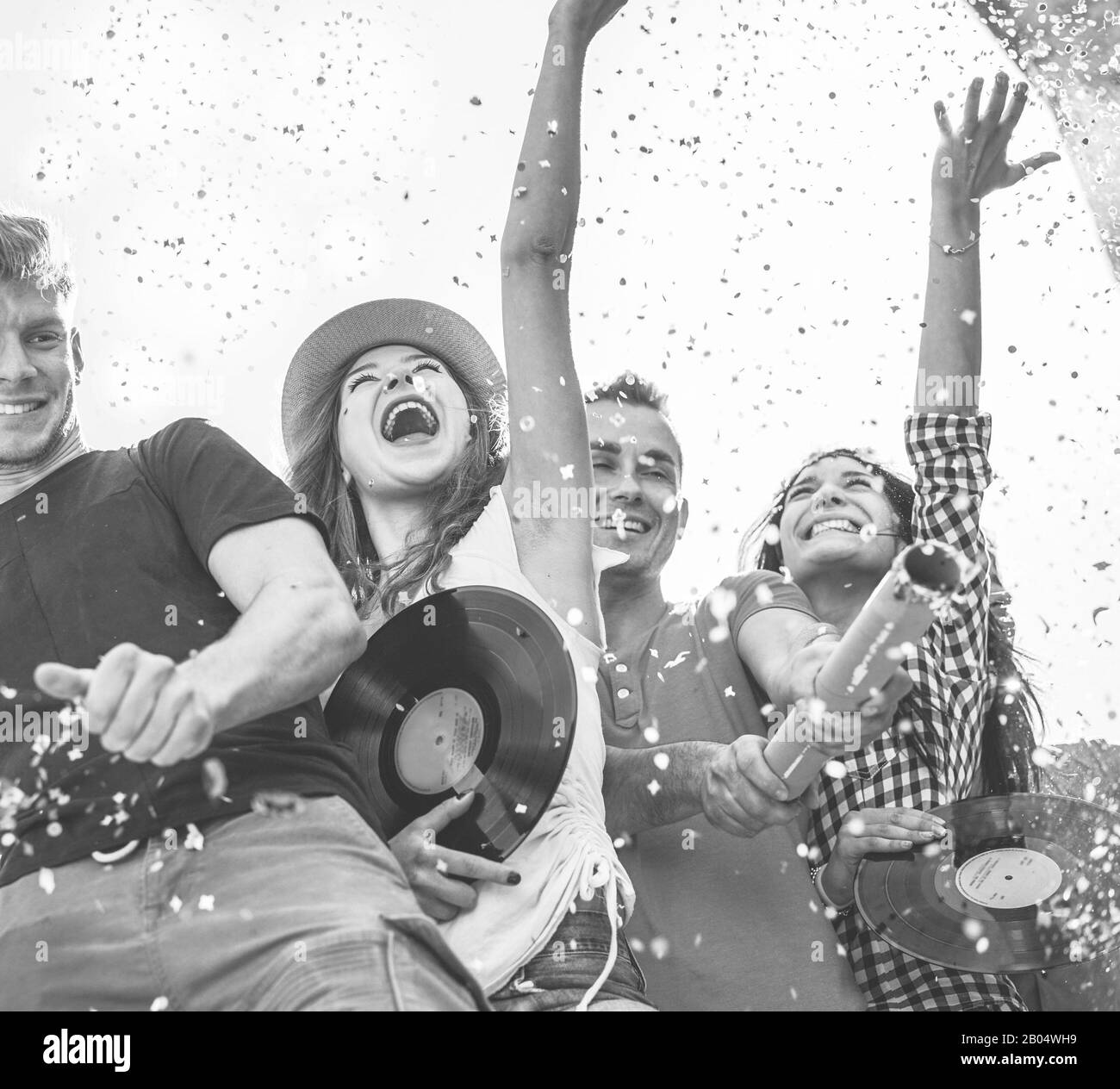 Amici felici lanciano confetti al festival del concerto di festa - giovani che si divertono a ballare all'aperto - amicizia, musica, vintage, evento e gioventù conc Foto Stock