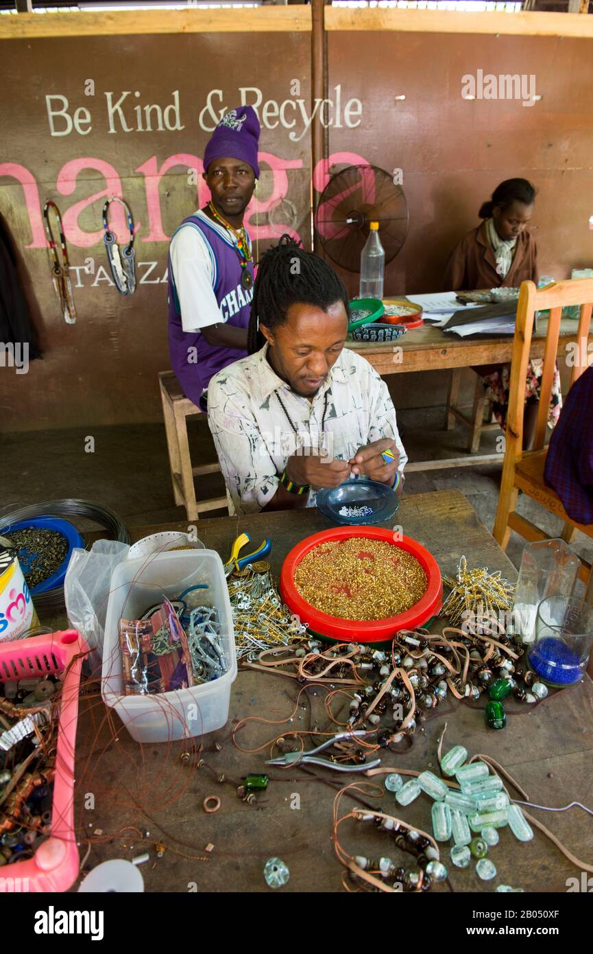 Persone disabili locali che fanno artigianato utilizzando materiali riciclati per il mercato all'ingrosso e al dettaglio dei consumatori presso la Shanga House di Arusha, in Tanzania Foto Stock
