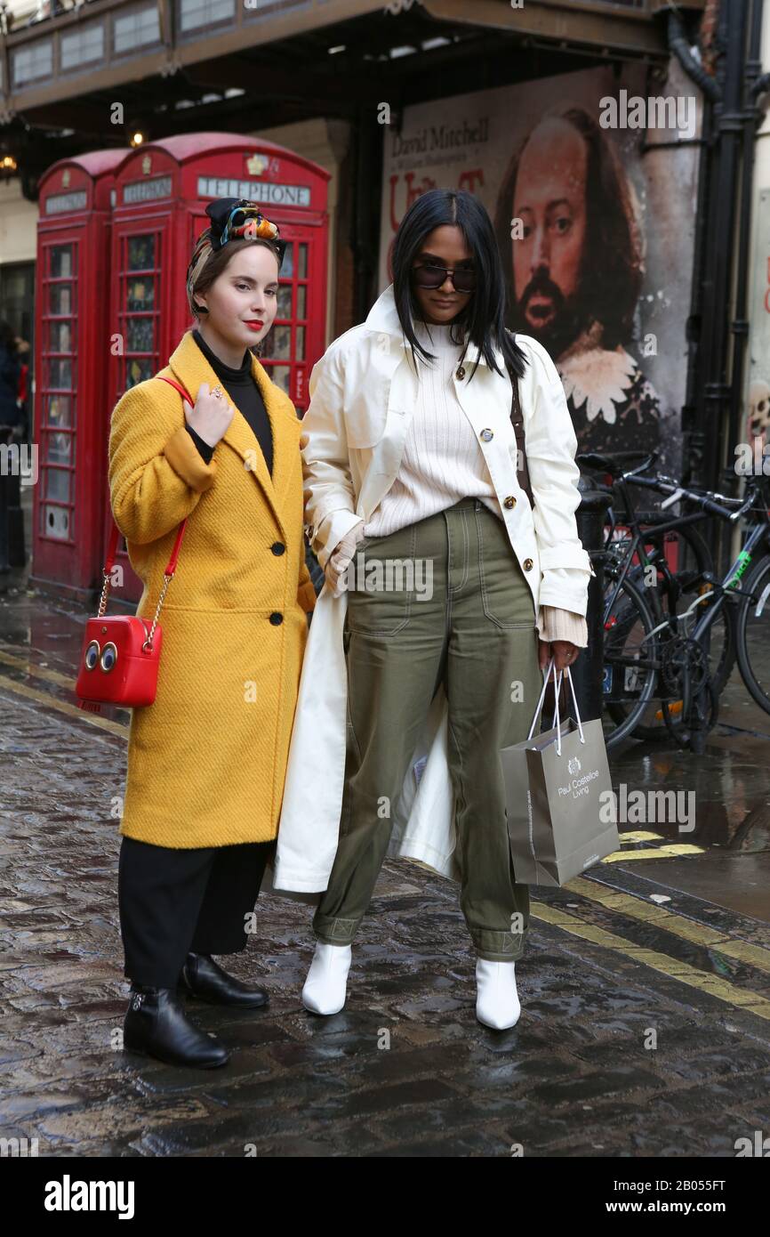 Due donne Alla Moda posano per una foto durante la settimana della moda di Londra, lo Stile femminile Day Four Street nel centro di Londra. Foto Stock