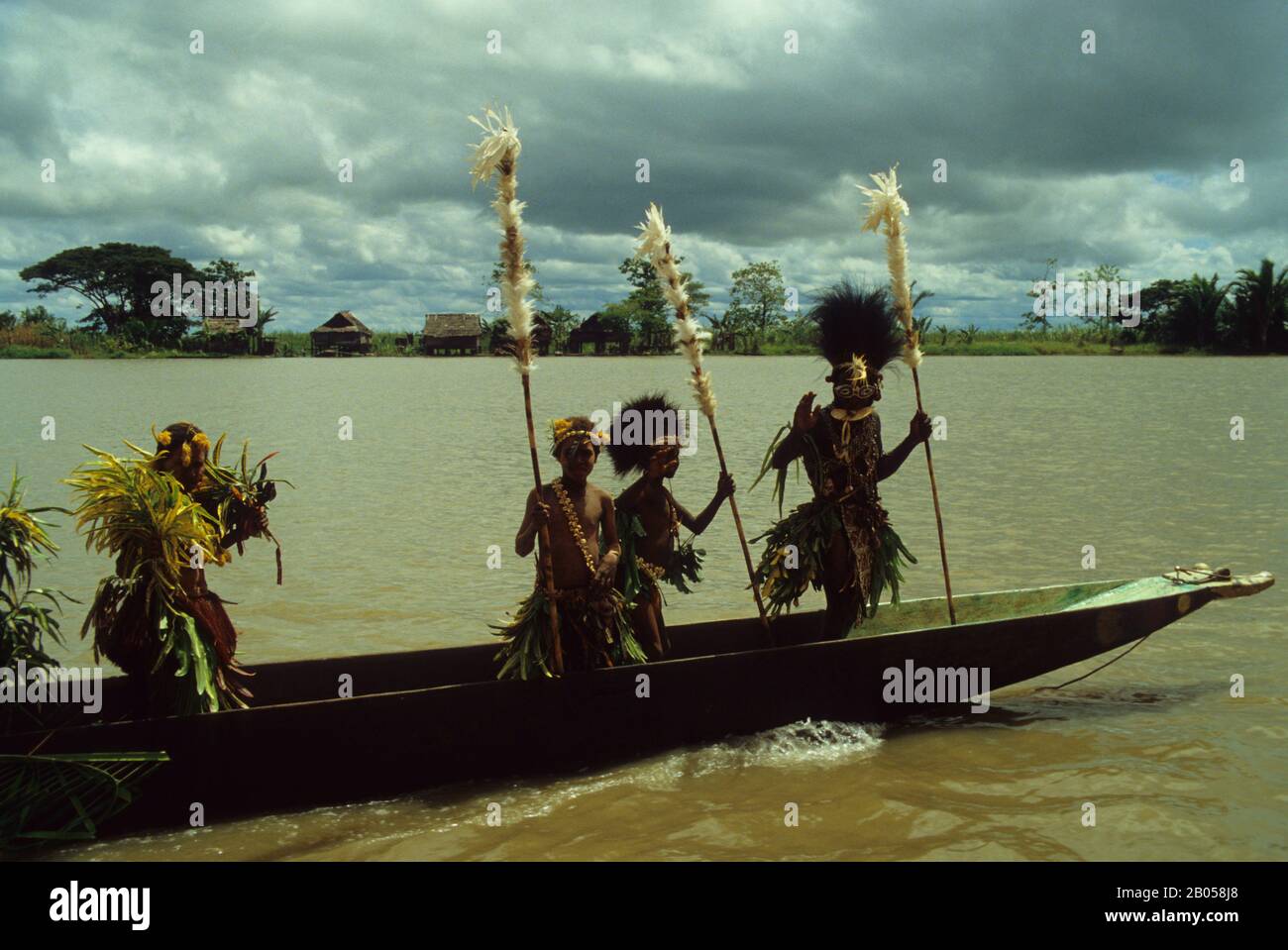 PAPUA NUOVA GUINEA, SEPIK RIVER, TRADIZIONALE CANOA DA GUERRA CON TRIBESMEN CERIMONIALI Foto Stock