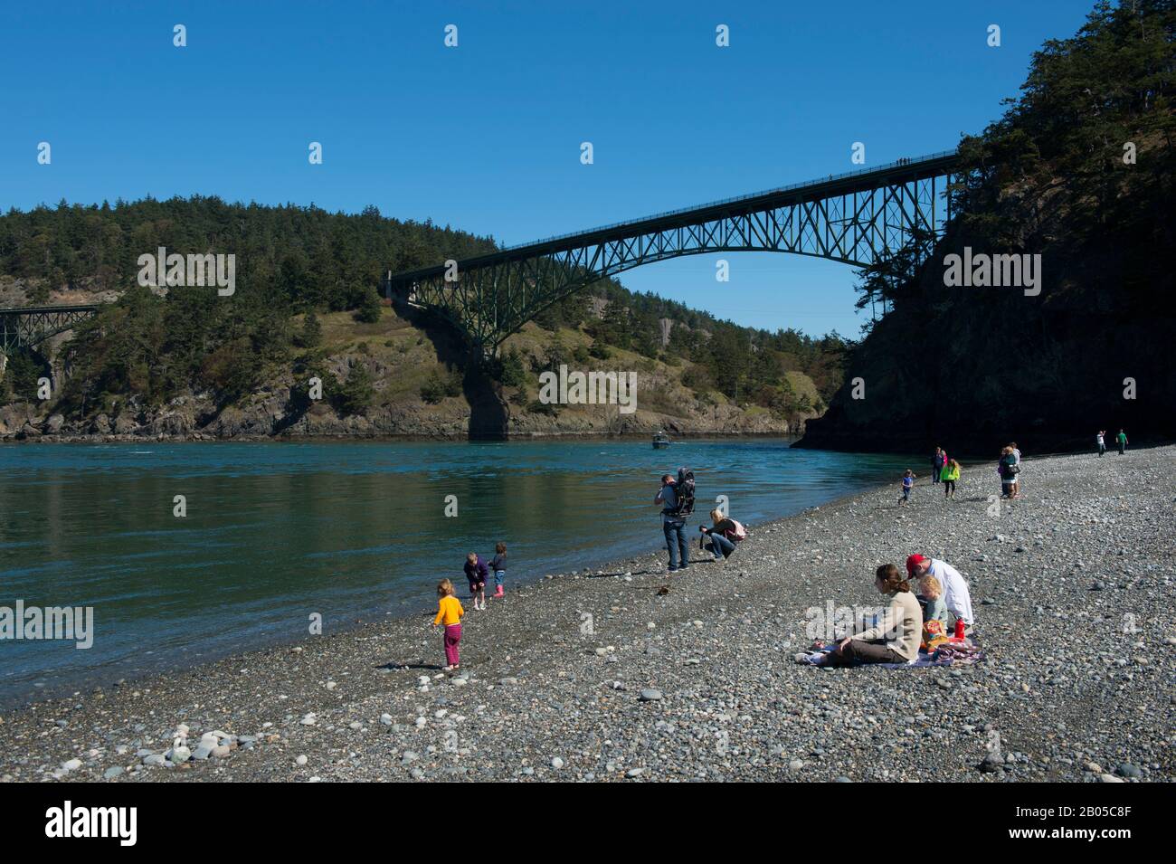 Persone su North Beach of Deception Pass state Park su Whidbey Island, Washington state, Stati Uniti con Deception Pass ponte in background Foto Stock