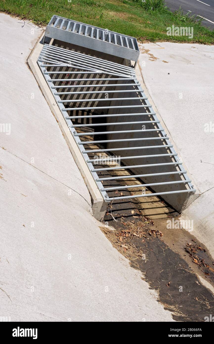 Uno scarico d'acqua in cemento e metallo appena costruito come parte di un progetto di costruzione di strade vicine Foto Stock