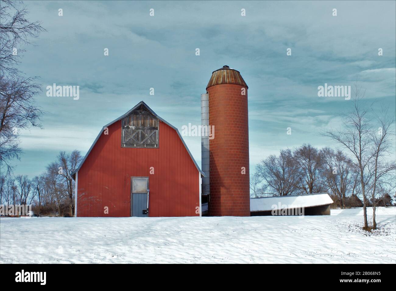 Kansas Red Country Barn con un silo in inverno con neve fuori nel paese. Foto Stock