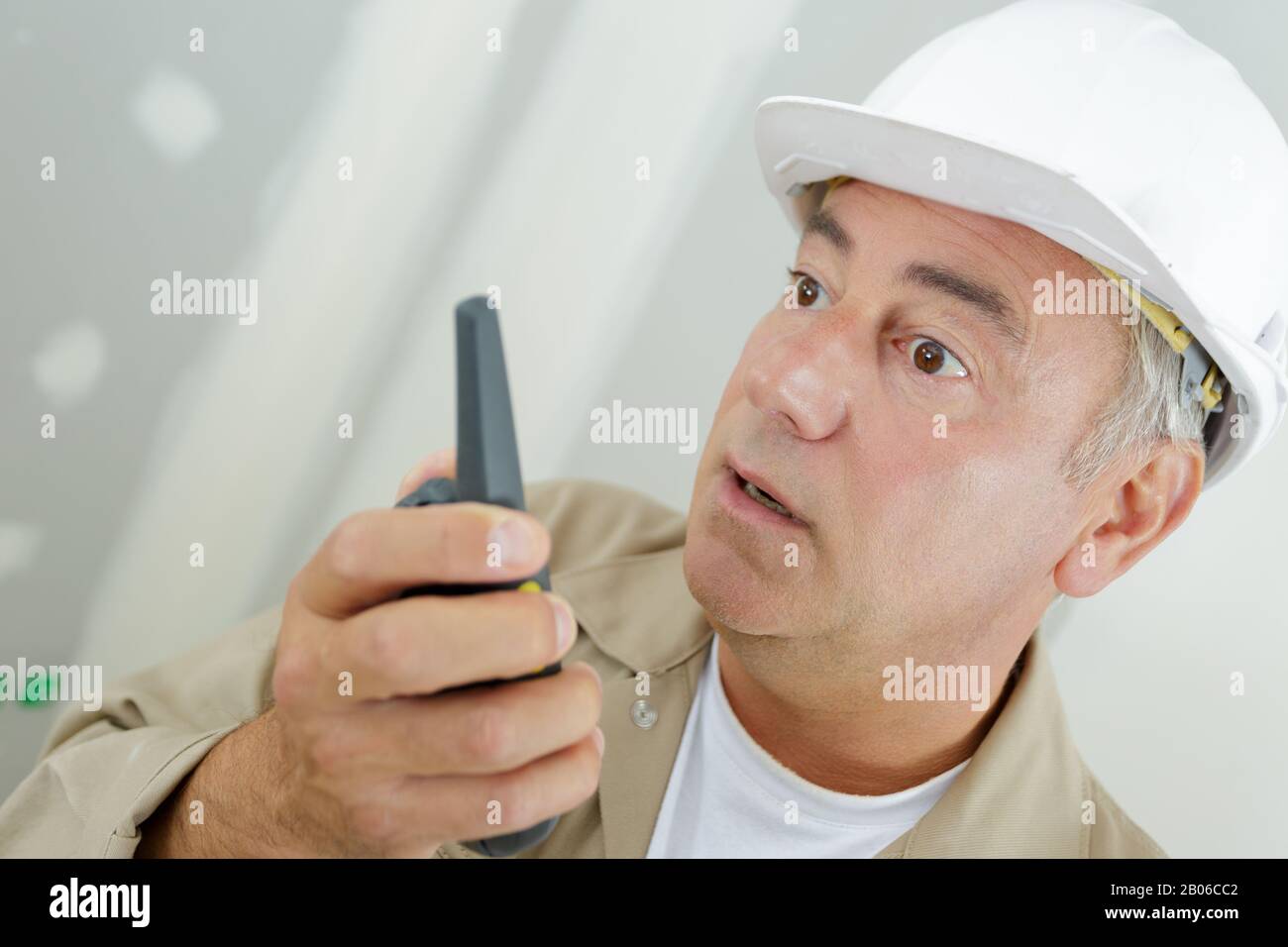lavoratore di costruzione che parla con un walkie talkie Foto Stock