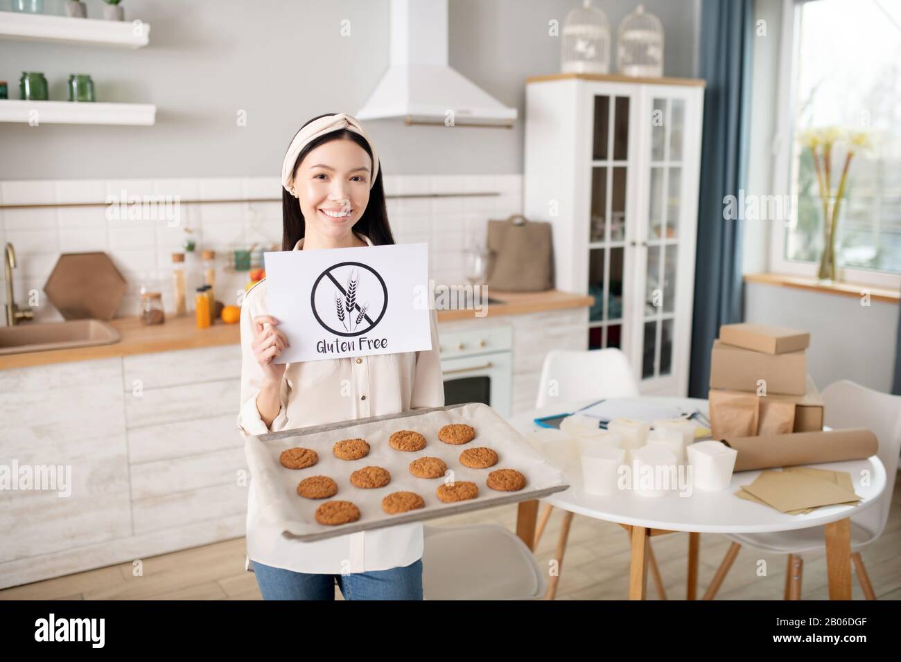 Ragazza giovane con torte fatte in casa e un poster nelle sue mani. Foto Stock