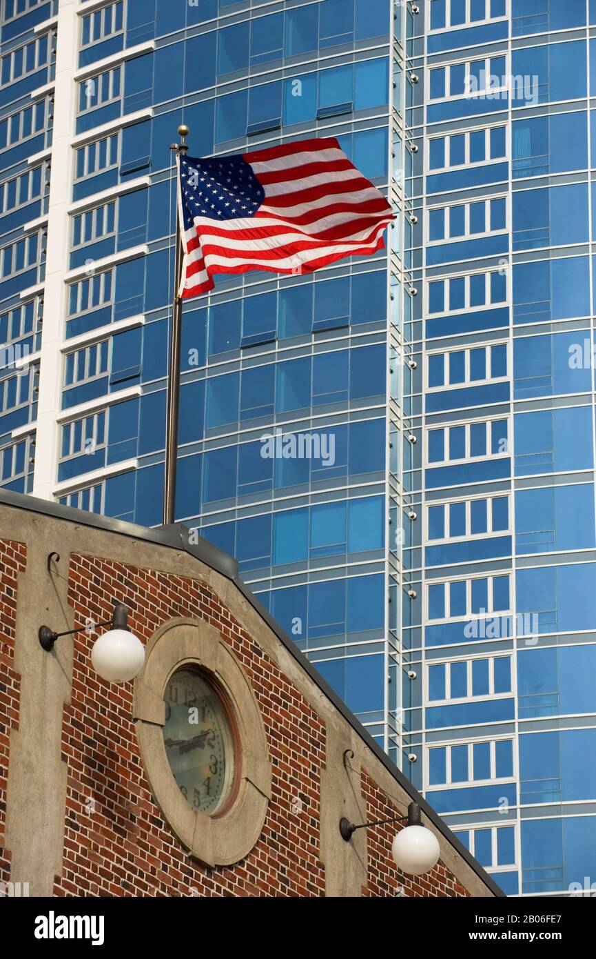 USA, WASHINGTON STATE, SEATTLE, PIKE PLACE MARKET, BANDIERA AMERICANA CON GRATTACIELO MODERNO SULLO SFONDO Foto Stock