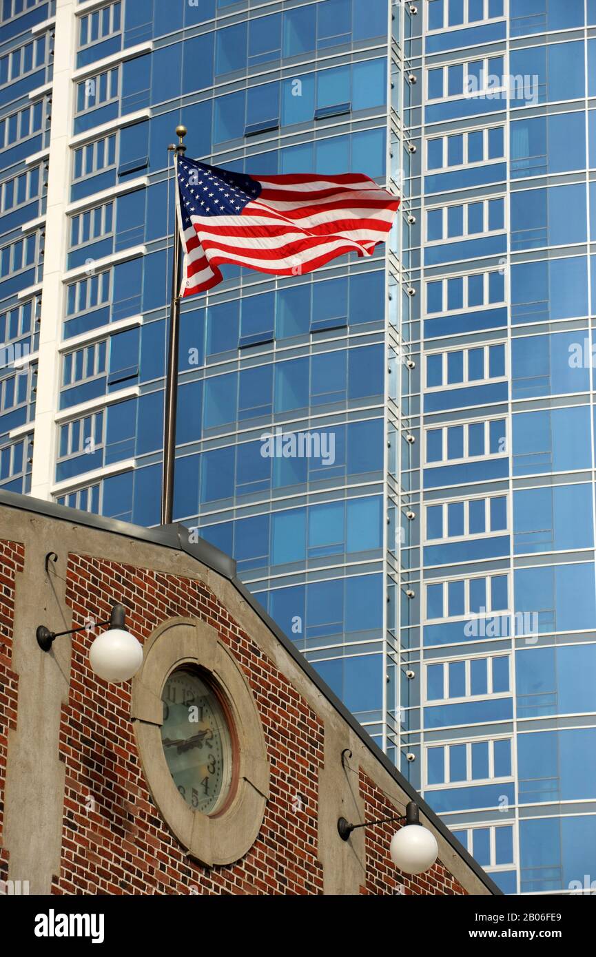 USA, WASHINGTON STATE, SEATTLE, PIKE PLACE MARKET, BANDIERA AMERICANA CON GRATTACIELO MODERNO SULLO SFONDO Foto Stock