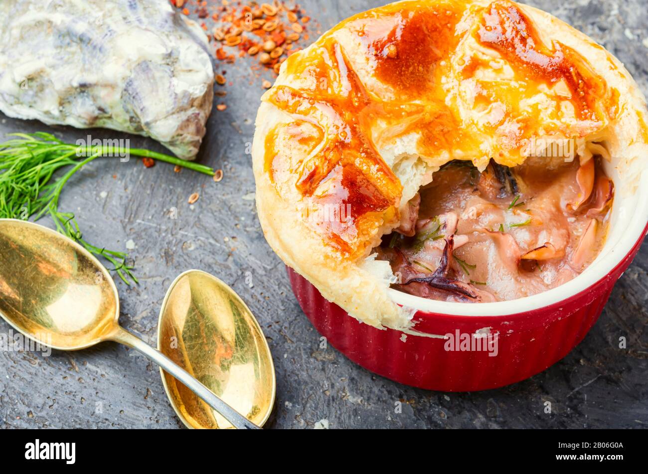 Zuppa di calamari e frutti di mare con pane cap.Seafood julienne. Foto Stock