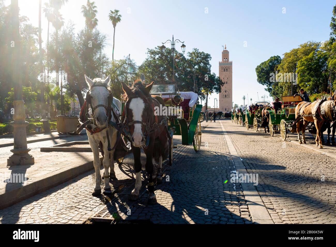 Carrozze in attesa per i turisti nella parte anteriore della famosa moschea di Marrakech, Marocco Foto Stock