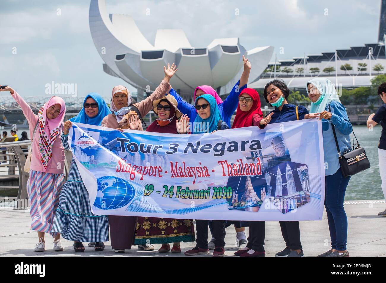 Diverse generazioni di donne musulmane hanno fatto felicemente una foto di gruppo insieme al loro banner di viaggio a Singapore. Sud-est asiatico Foto Stock