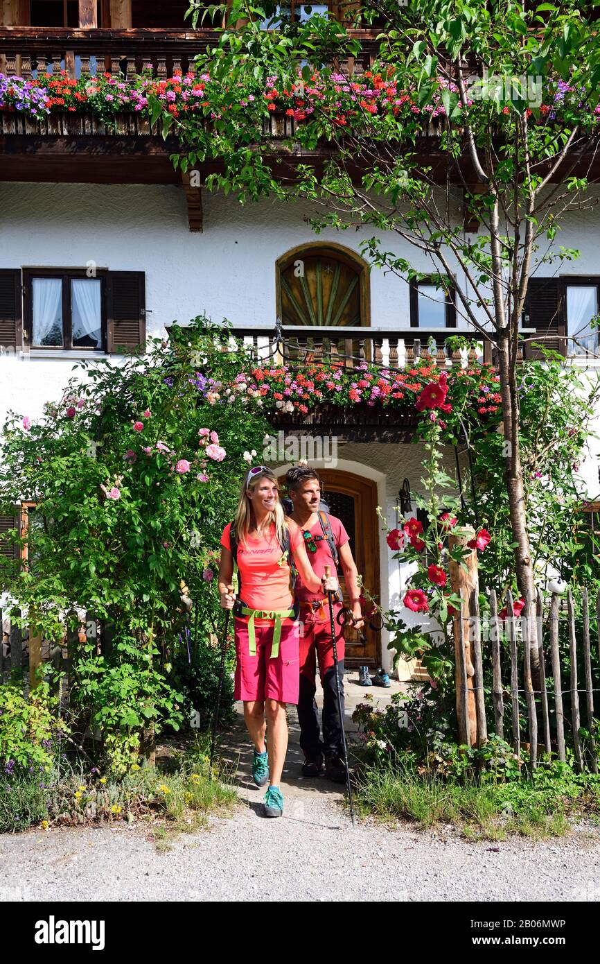 Gli escursionisti lasciano il bed and breakfast a Sachrang, Chiemgau, alta Baviera, Germania Foto Stock