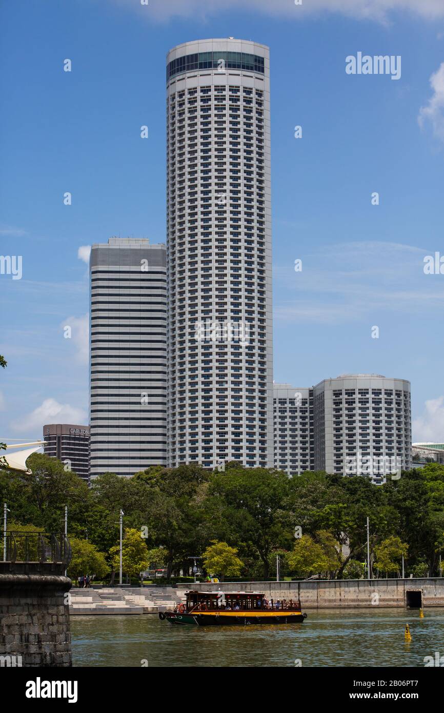 Bum boat sul fiume Singapore sullo sfondo del grattacielo Swissotel hotel. Foto Stock