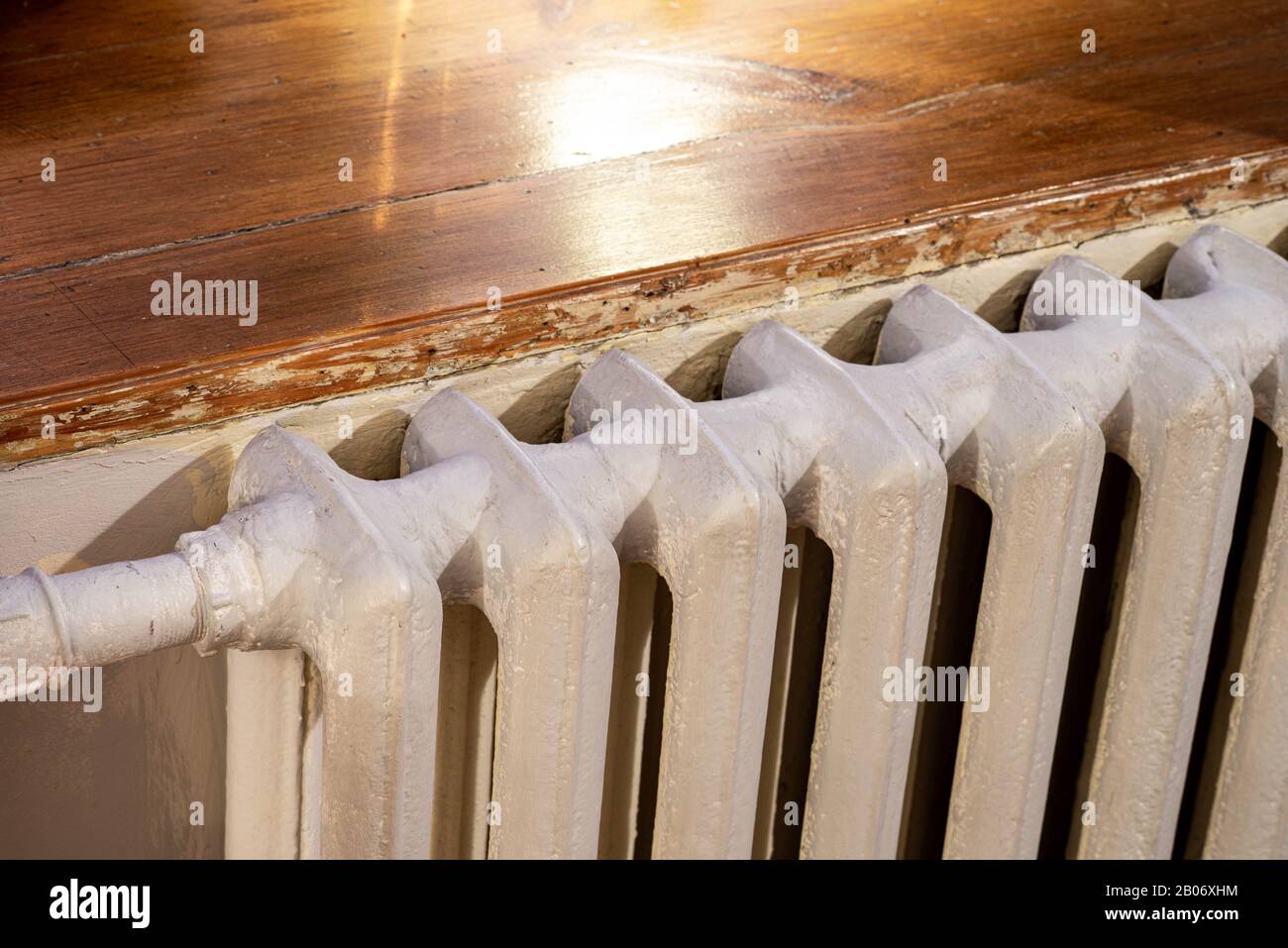 Primo piano della batteria di riscaldamento bianca in appartamento. Soglia in legno. Foto Stock