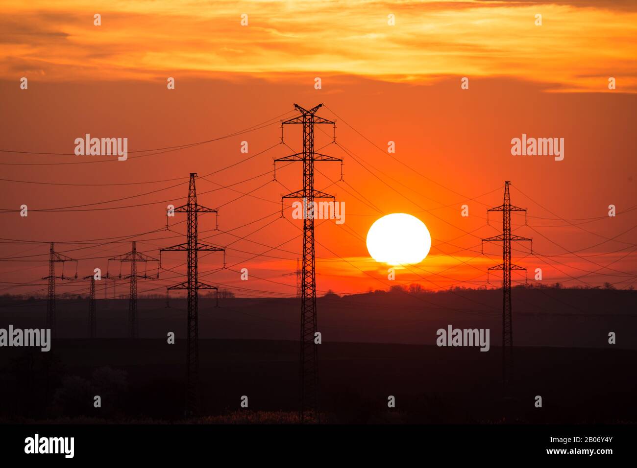 Vista in una silhouette di linee elettriche e colonne Colonna durante il tramonto con nuvole sul cielo. Bella natura tramonto. Paesaggio rurale con elettrico Foto Stock