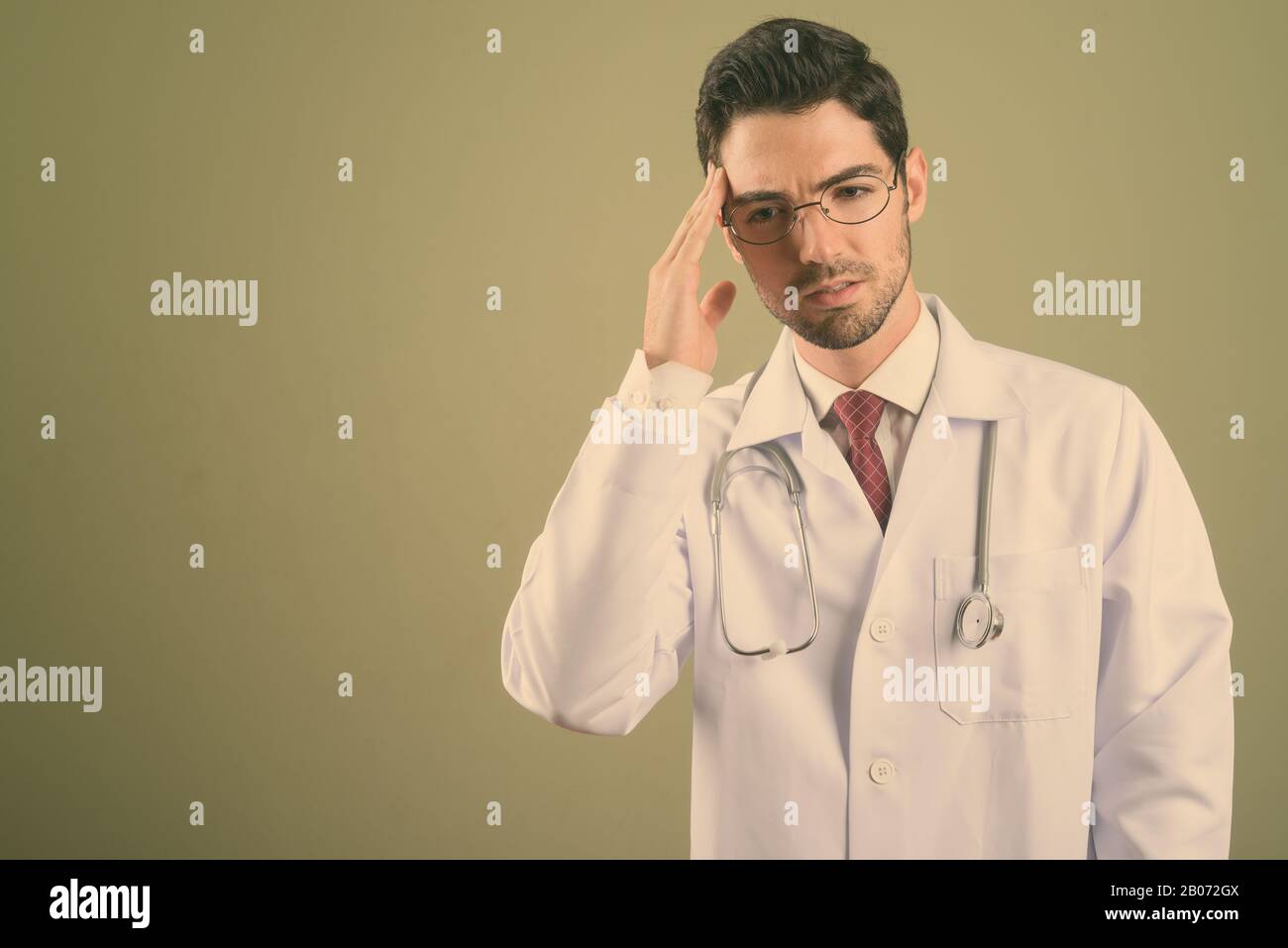 Giovane uomo bello medico contro sfondo colorato Foto Stock