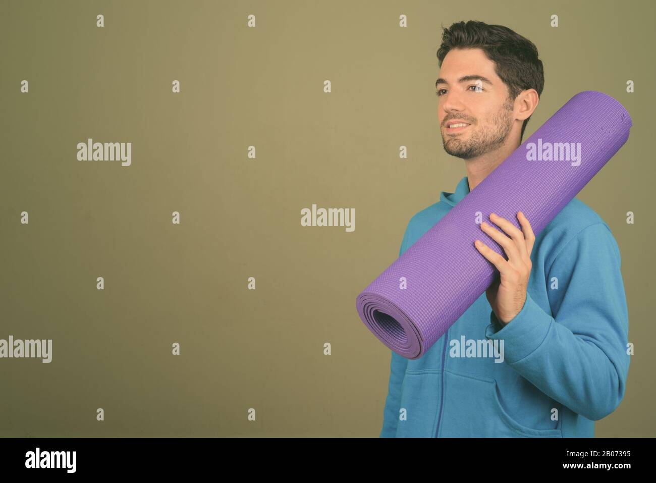 Giovane bell'uomo pronto per la palestra su sfondo colorato Foto Stock