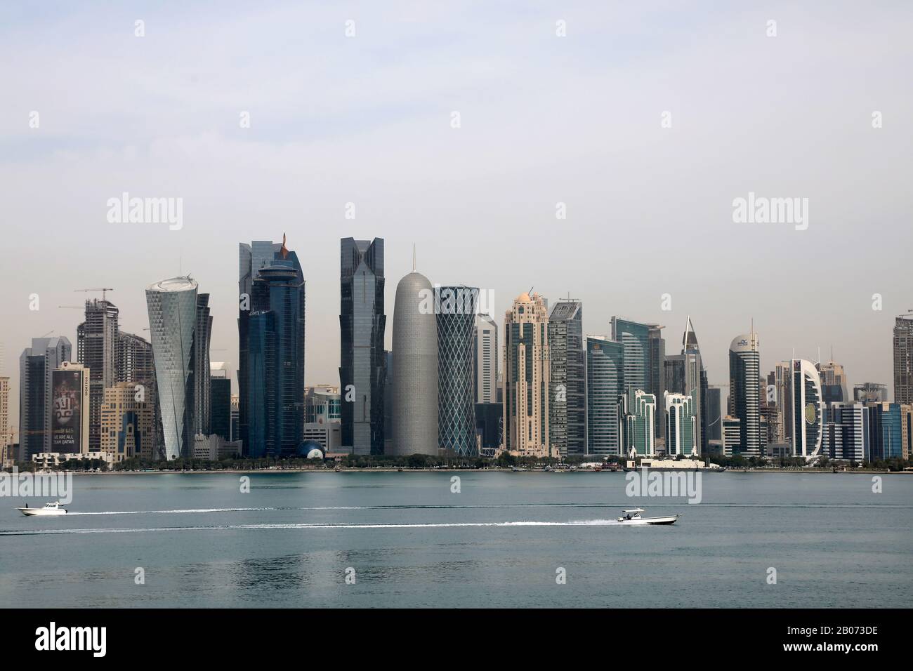Doha / Qatar – 18 febbraio 2020: I motoscafi si incrociano davanti alle torri della zona di Doha, il principale quartiere degli affari della città Foto Stock