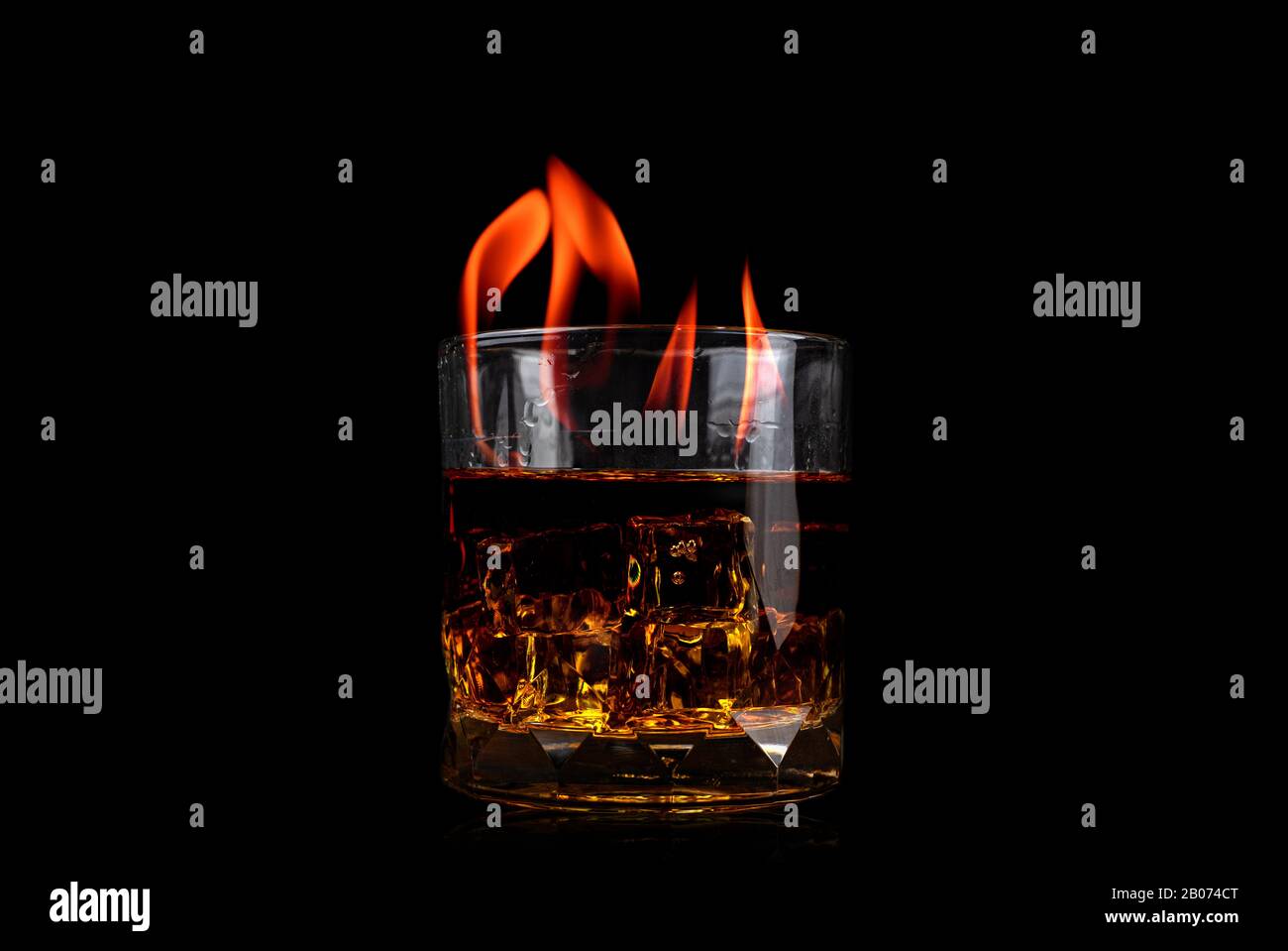 Vetro con whiskey di ghiaccio cubo e fuoco fiamma su sfondo nero Foto Stock