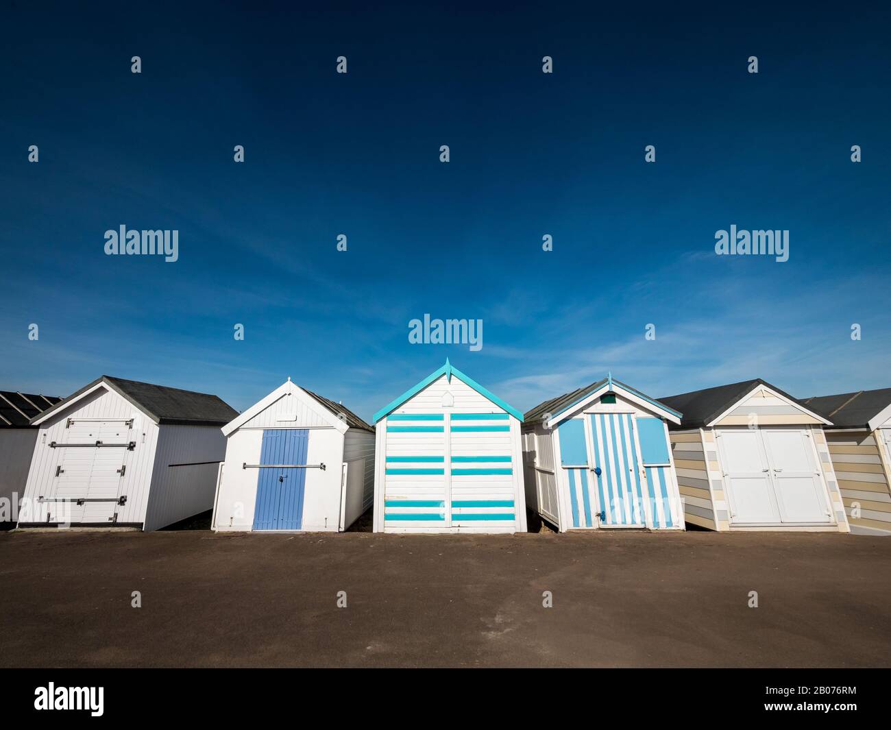 Tradizionale English Beach Huts. Una fila di capanne sulla spiaggia comunemente presenti nelle località balneari britanniche. Foto Stock