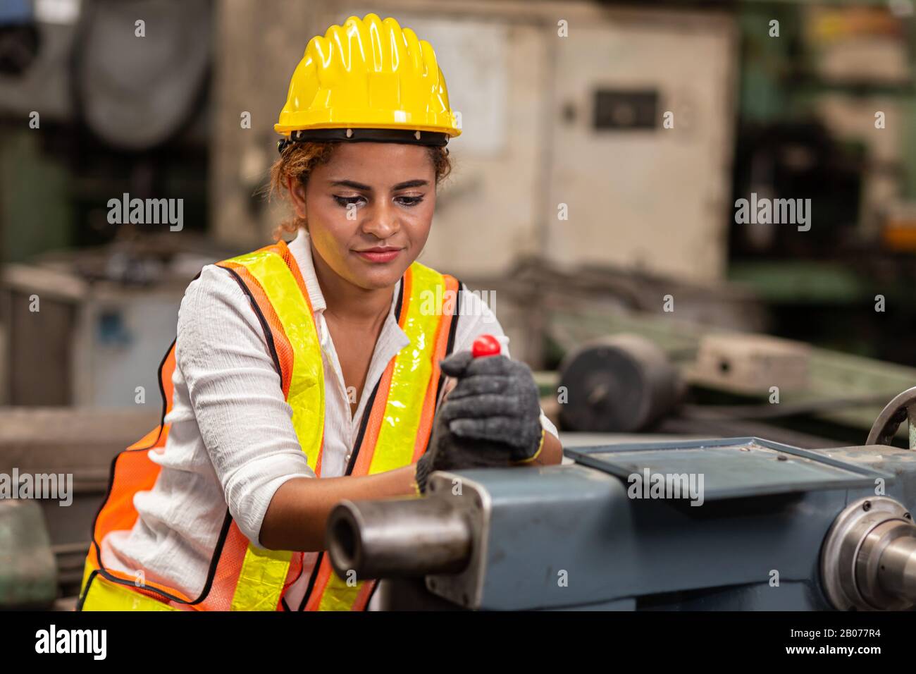 Ragazza teen lavoratore afro-americano lavoro in fabbrica di industria con macchina di acciaio pesante. Foto Stock