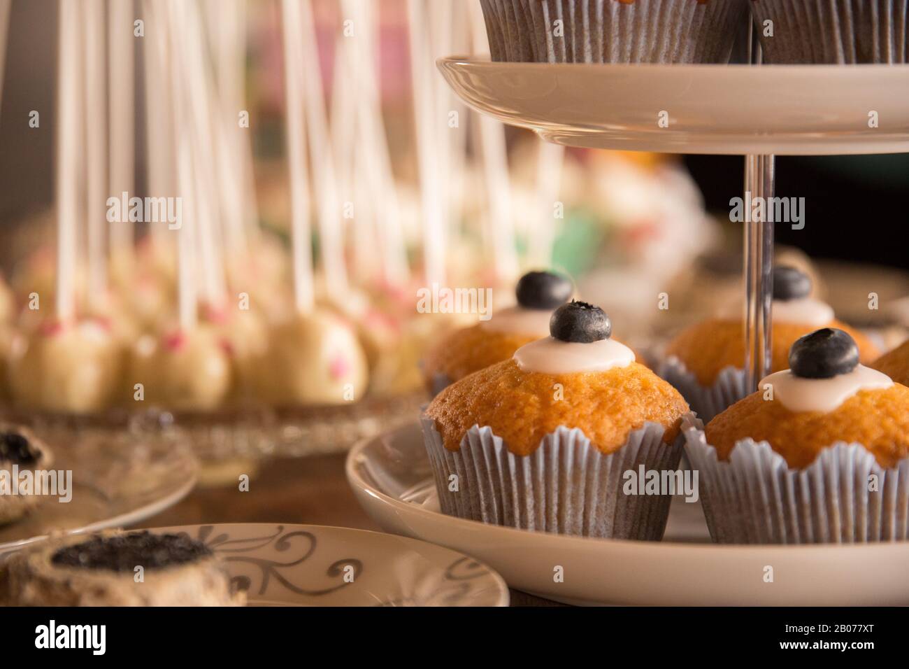 Cakepops e muffin disposti su un tavolo con bei colori caldi Foto Stock