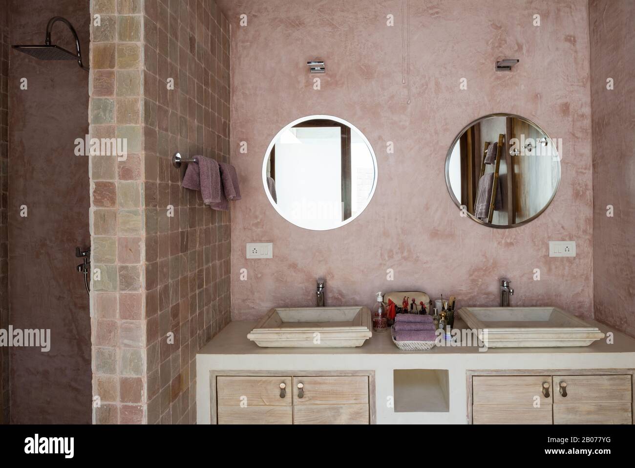 Bagno in tonalità rosa con specchi circolari Foto Stock