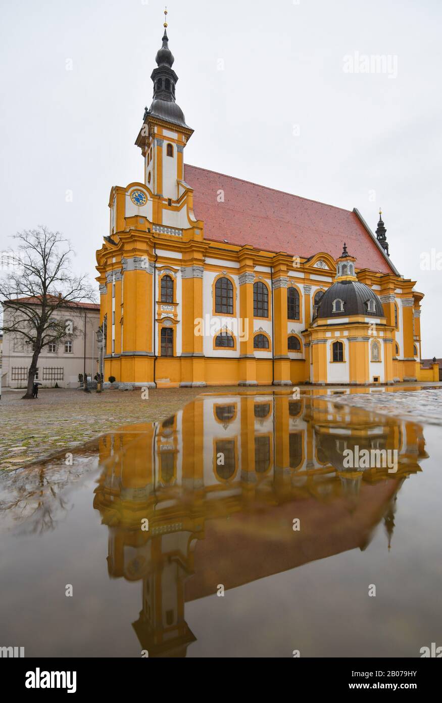 19 febbraio 2020, Brandeburgo, Neuzelle: La chiesa cattolica del monastero di Neuzelle si riflette in una pozza. Il monastero di Neuzelle, a circa dieci chilometri a sud di Eisenhüttenstadt, è l'unico monastero cistercense del Brandeburgo completamente conservato, comprese le strutture esterne, ed è uno dei pochi complessi monastici non distrutti in Germania e in Europa. Foto: Patrick Pleul/dpa-Zentralbild/ZB Foto Stock