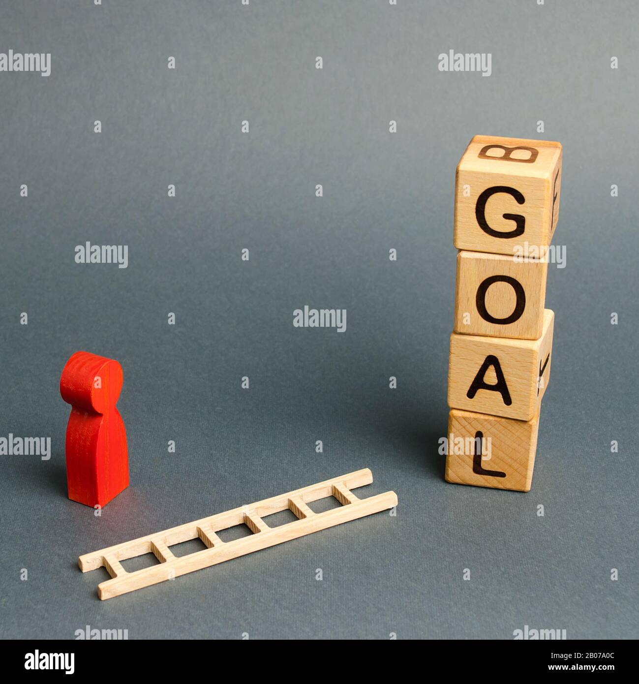 Blocchi torre con parola Obiettivo e un uomo figurina con una scala caduta. Obiettivi di strumenti e tattiche, puzzle solving. Ricerca di soluzioni in a Foto Stock