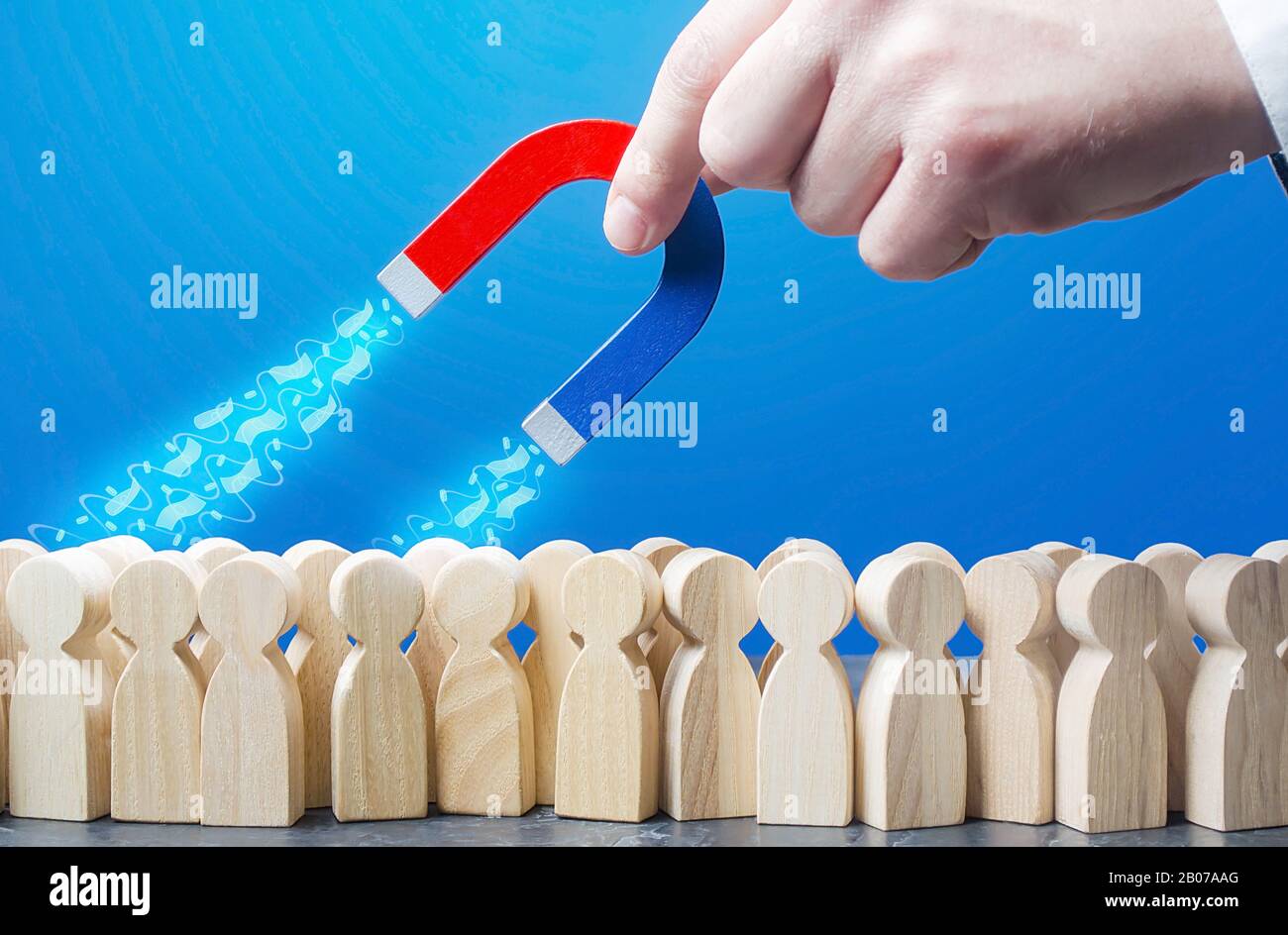 Un uomo attrae soldi da una folla di persone con un magnete. Riscossione delle imposte, donazioni. Crowdfunding e la ricerca di start-up di affari di finanziamento. Fra Foto Stock