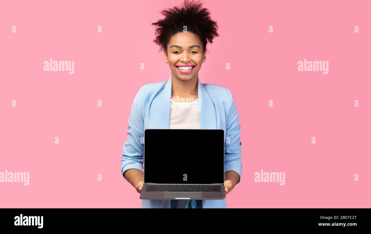 Ragazza nera felice che mostra nero schermo vuoto del computer Foto Stock