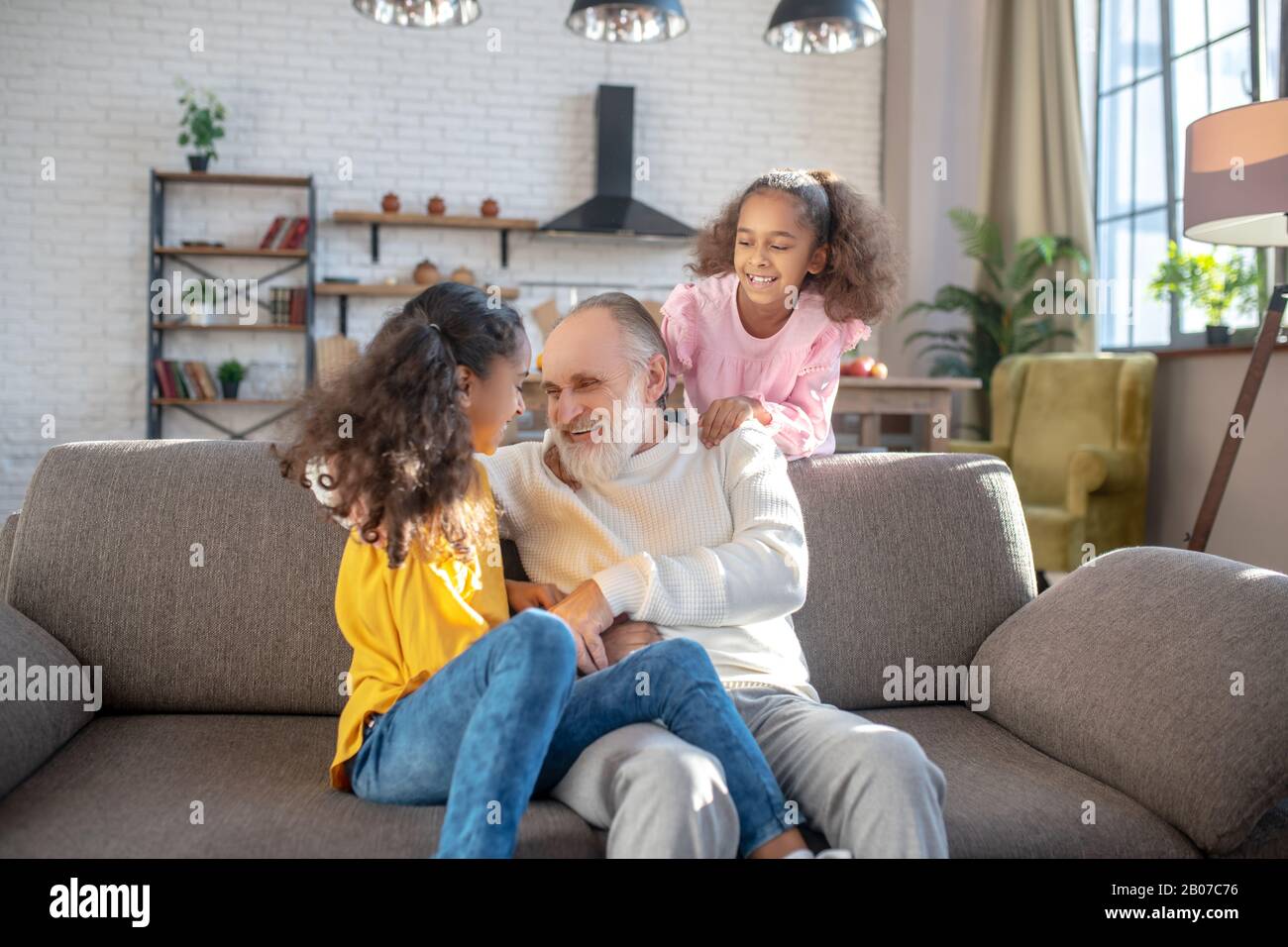 Due sorelle di pelle scura che parlano con il loro nonno Foto Stock