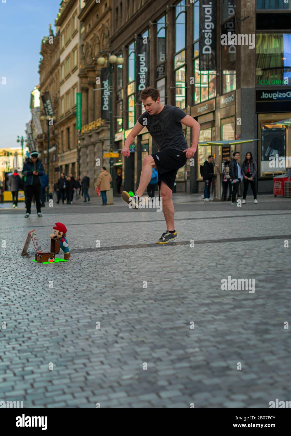 Praga - Febbraio 9th 2019: A Street Performer fa trucchi con una palla da tennis verde nel centro della città con una folla di spettatori. Foto Stock