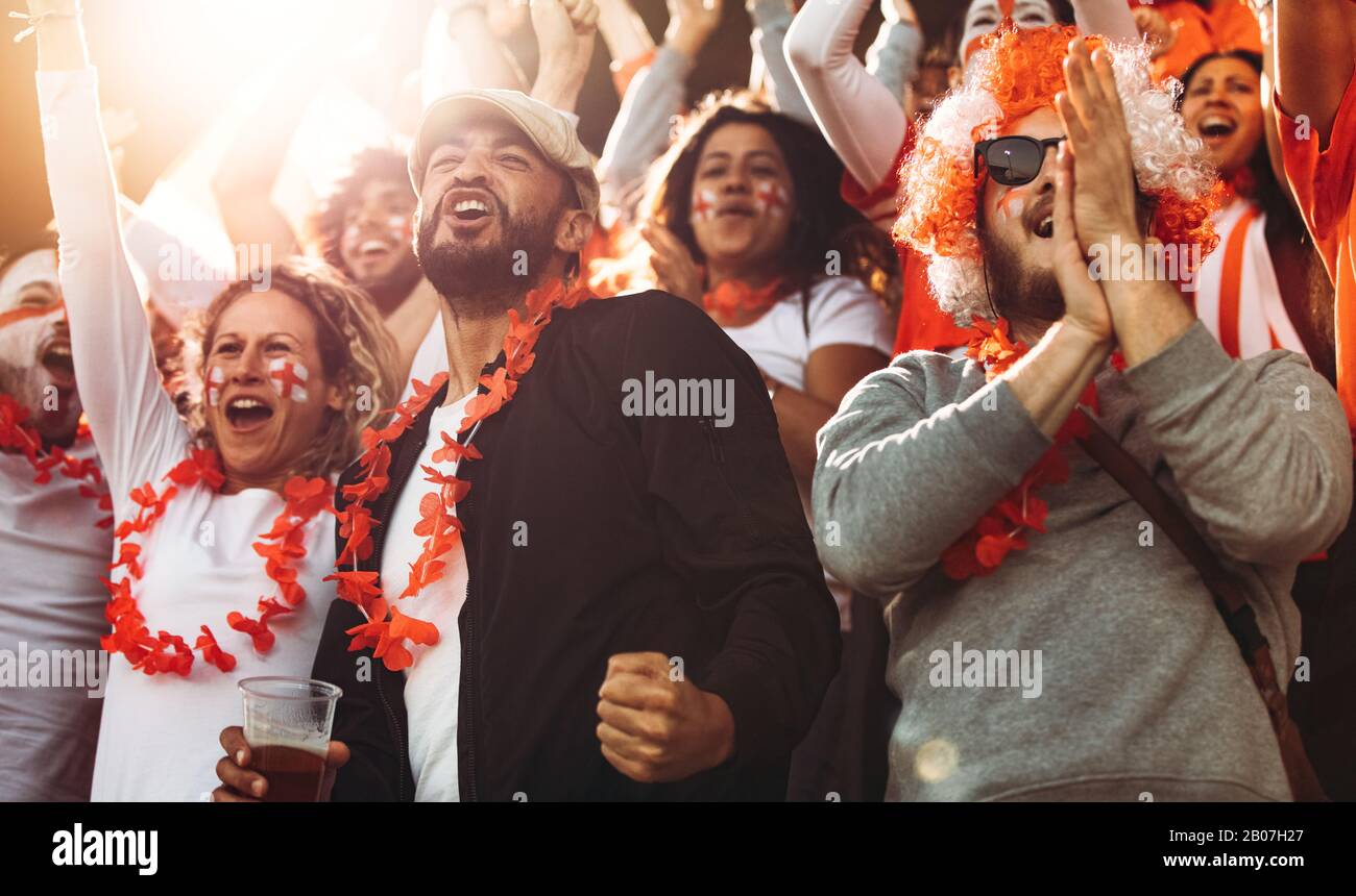 Gli appassionati di calcio dell'Inghilterra celebrano la vittoria. Spettatori inglesi che si godono dopo una vittoria di campionato allo stadio. Foto Stock