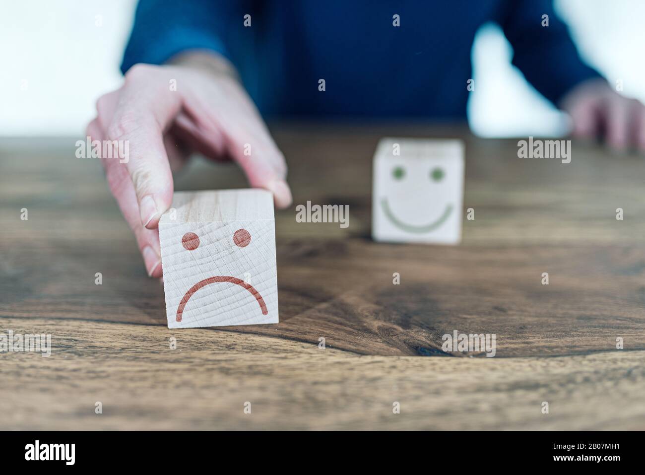 valutazione del servizio clienti e concetto di feedback con volti sorridenti e tristi su blocchi di legno giocattolo Foto Stock