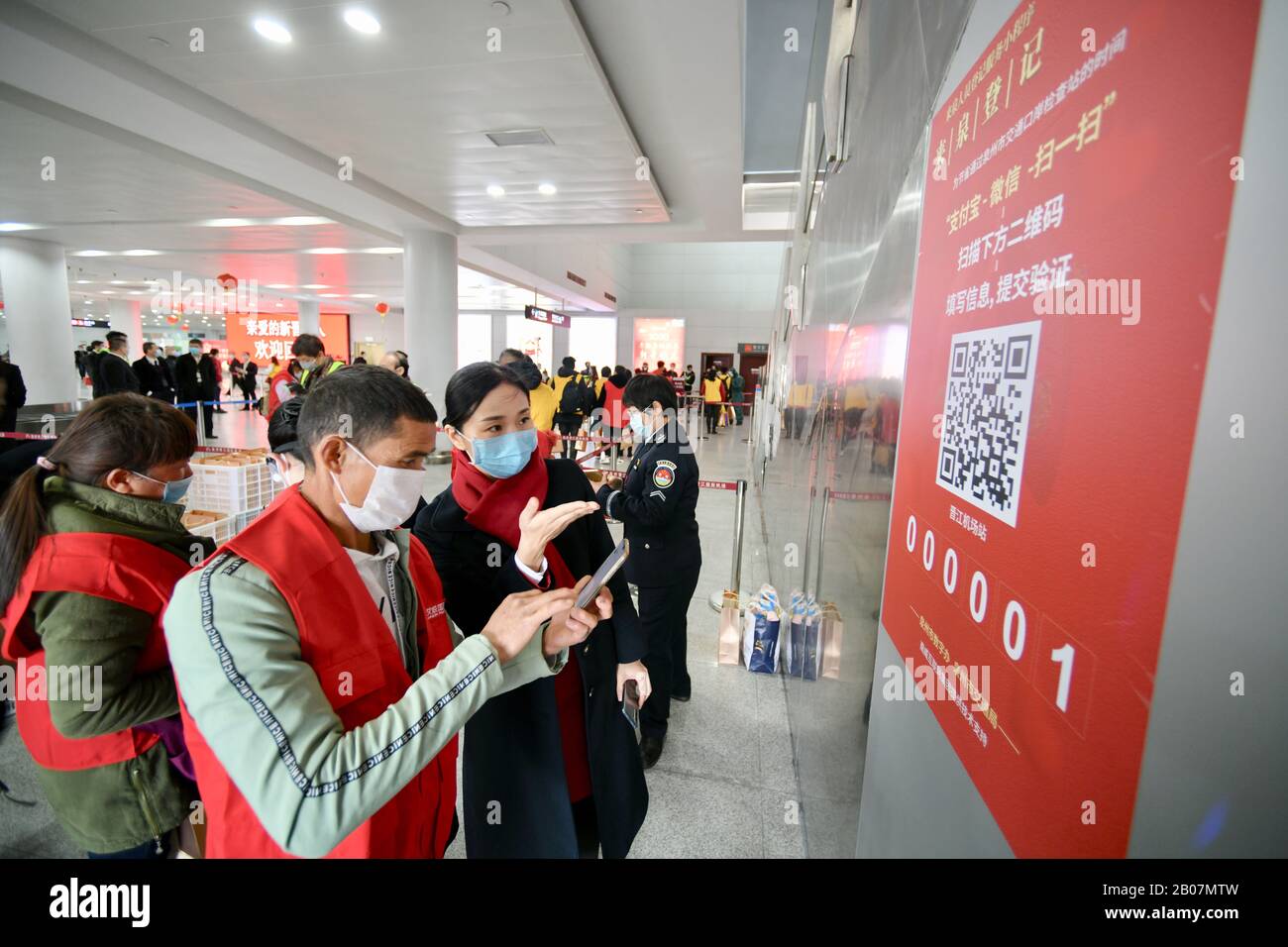 Quanzhou, Cina. 19th Feb 2020. Un membro del personale aiuta i lavoratori che ritornano dalla provincia di Yunnan a registrarsi all'aeroporto internazionale di Jinjiang a Quanzhou, nella provincia Fujian della Cina sudorientale, 19 febbraio 2020. Il volo charter DR5345 di Ruili Airlines ha portato 101 lavoratori di ritorno dalla città di Mangshi, nella provincia di Yunnan nella Cina sudoccidentale, a Quanzhou, nella provincia Fujian della Cina sudorientale, il mercoledì. È il primo volo charter per i lavoratori di ritorno che sono arrivati nella provincia di Fujian dopo lo scoppio del nuovo coronavirus. (Xinhua/Jiang Kehong) Credito: Xinhua/Alamy Live News Foto Stock
