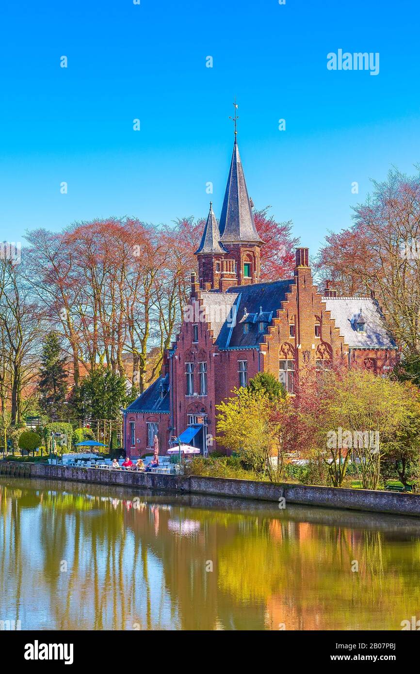 Bruges, Belgio Minnewater Lake of Love panorama, Ponte Degli Innamorati, caffè del castello, cielo blu Foto Stock