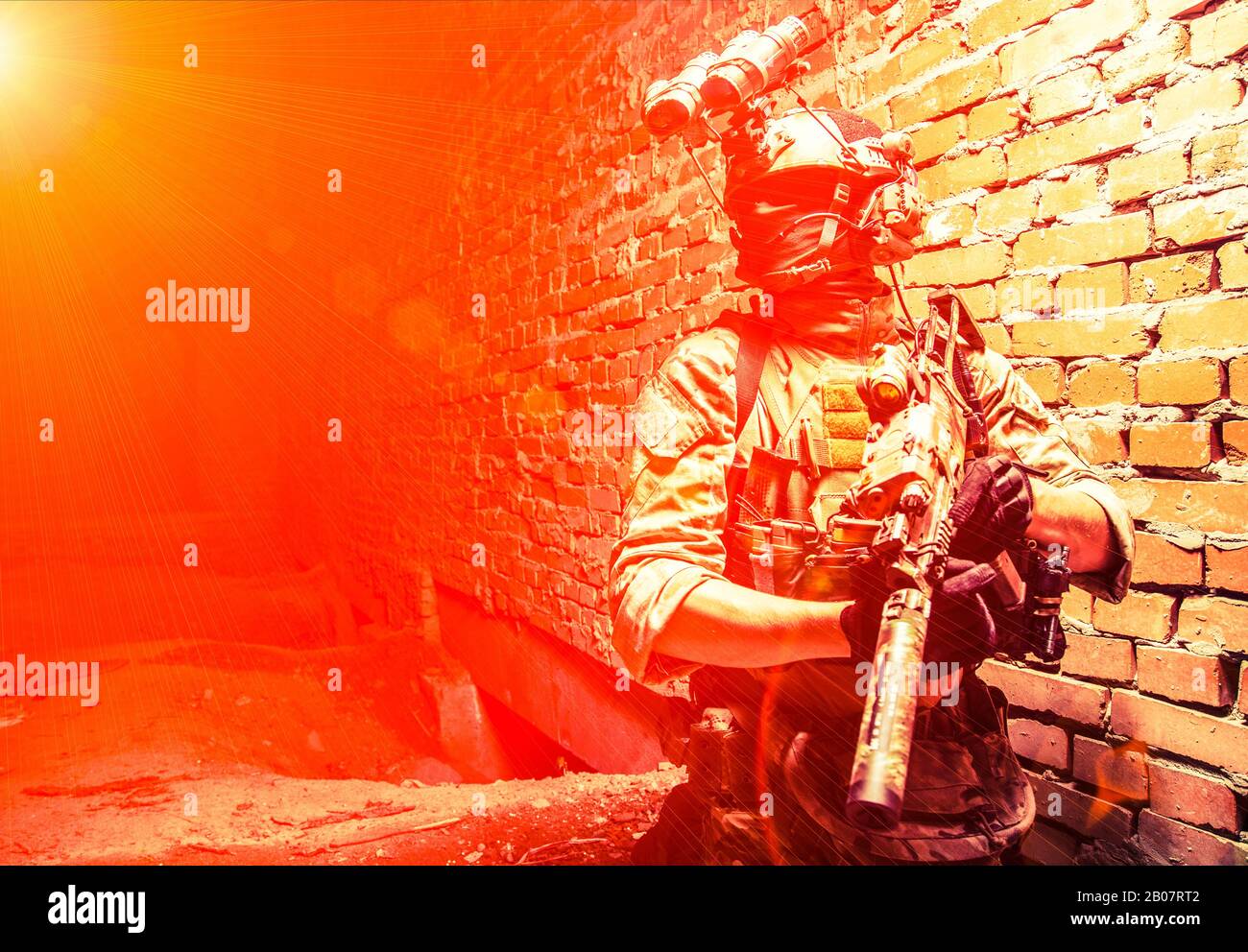 Operazioni speciali forze soldato, lotta al terrorismo assalto squadra combattente con dispositivo di visione notturna su casco e fucile di servizio, chiave bassa indoor colpo muro di mattoni Foto Stock