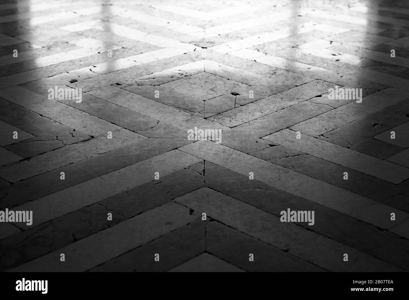 Pavimento in mosaico in pietra lucida di vecchio stile con motivo geometrico, sfondo bianco e nero texture foto Foto Stock