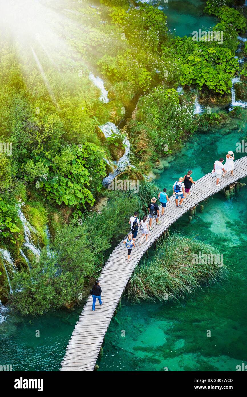 I turisti camminano su un sentiero in legno, nel Parco Nazionale dei Laghi di Plitvice, patrimonio dell'umanità dell'UNESCO. Foto Stock