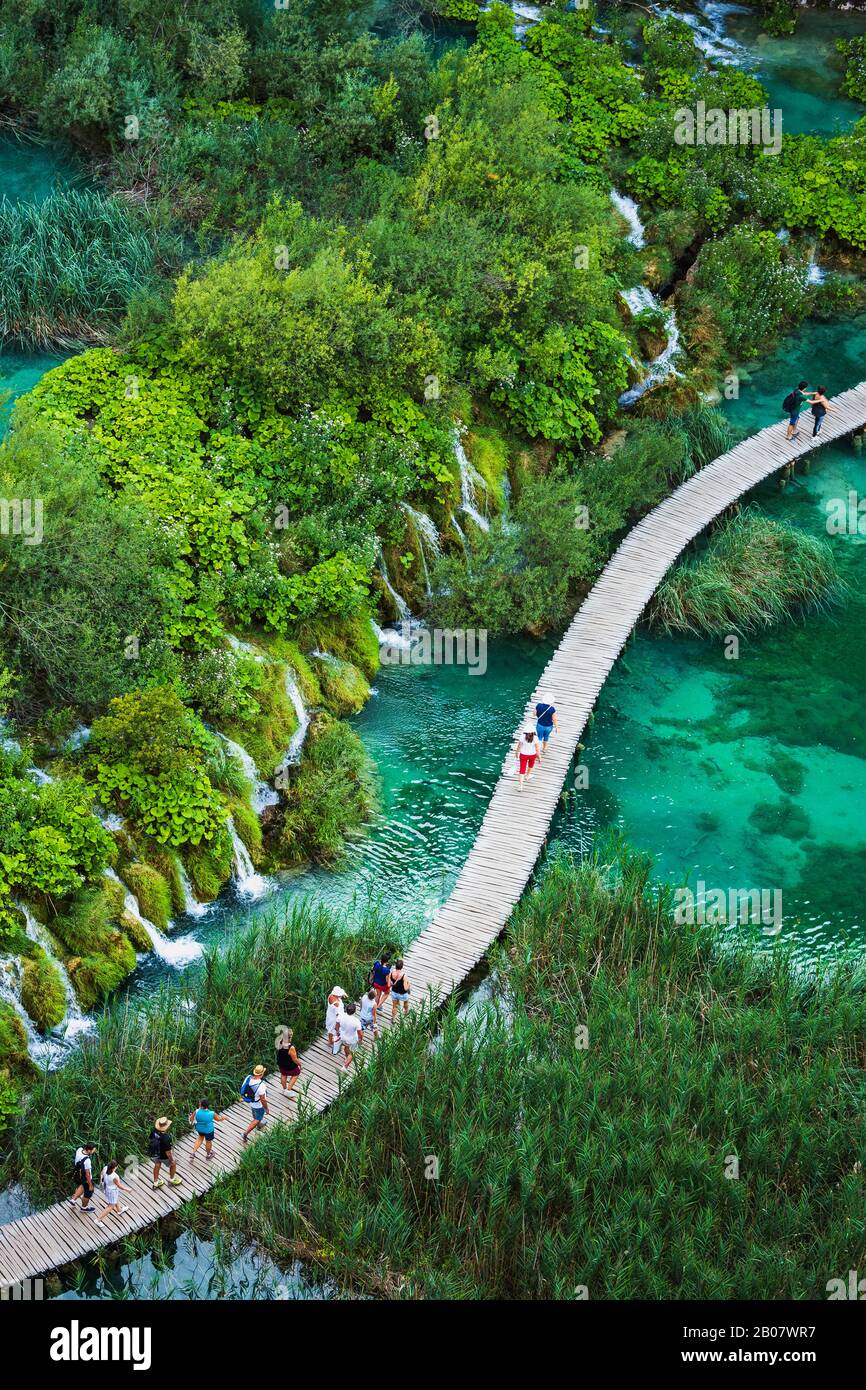 I turisti camminano su un sentiero in legno, nel Parco Nazionale dei Laghi di Plitvice, patrimonio dell'umanità dell'UNESCO. Foto Stock