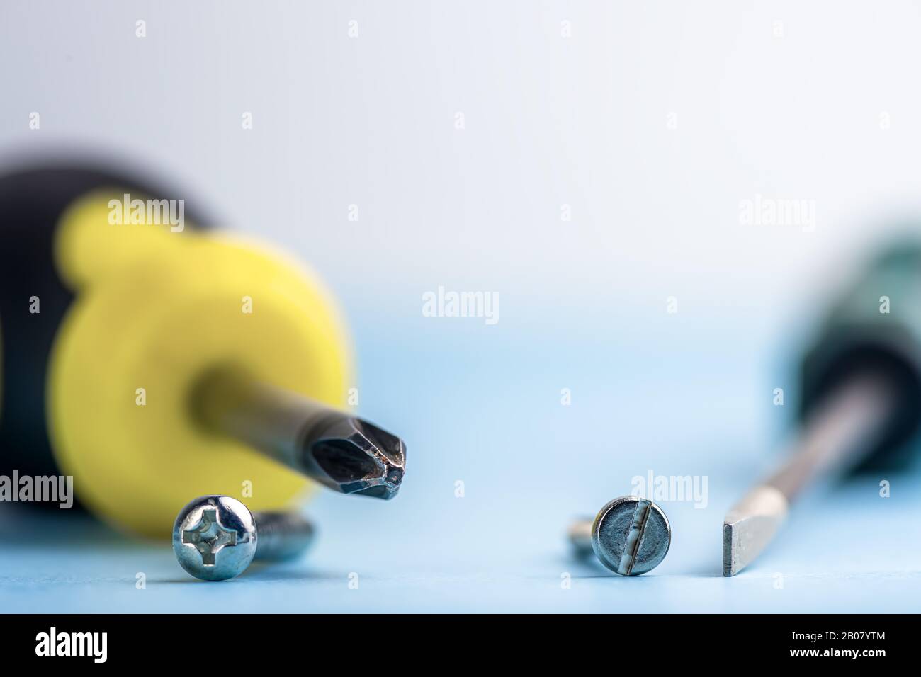 primo piano di diversi cacciaviti sono a croce e piatti e coss adatti su sfondo azzurro. Strumenti. Compatibilità. Riparazione Foto Stock
