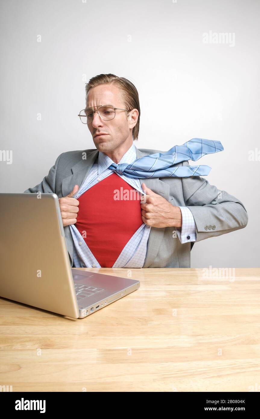 Un uomo d'affari super eroe si prepara a salvare la giornata dalla sua scrivania Foto Stock