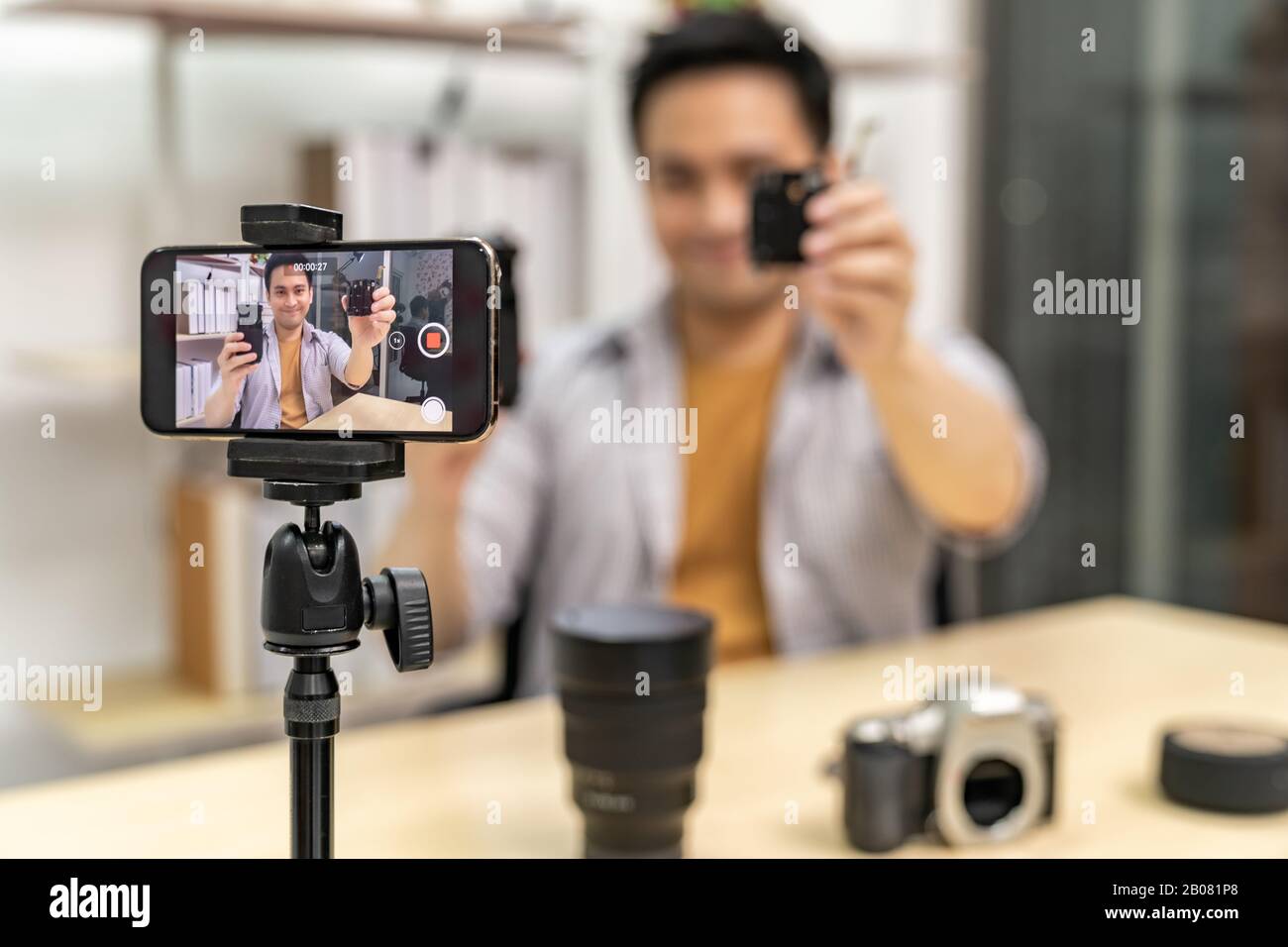 Giovani asiatici maschi VLOGGER E blogger vivono su fotocamera digitale tecnologia aggiornare utilizzando il telefono cellulare per registrare video vlog dal vivo. Online influcenc Foto Stock