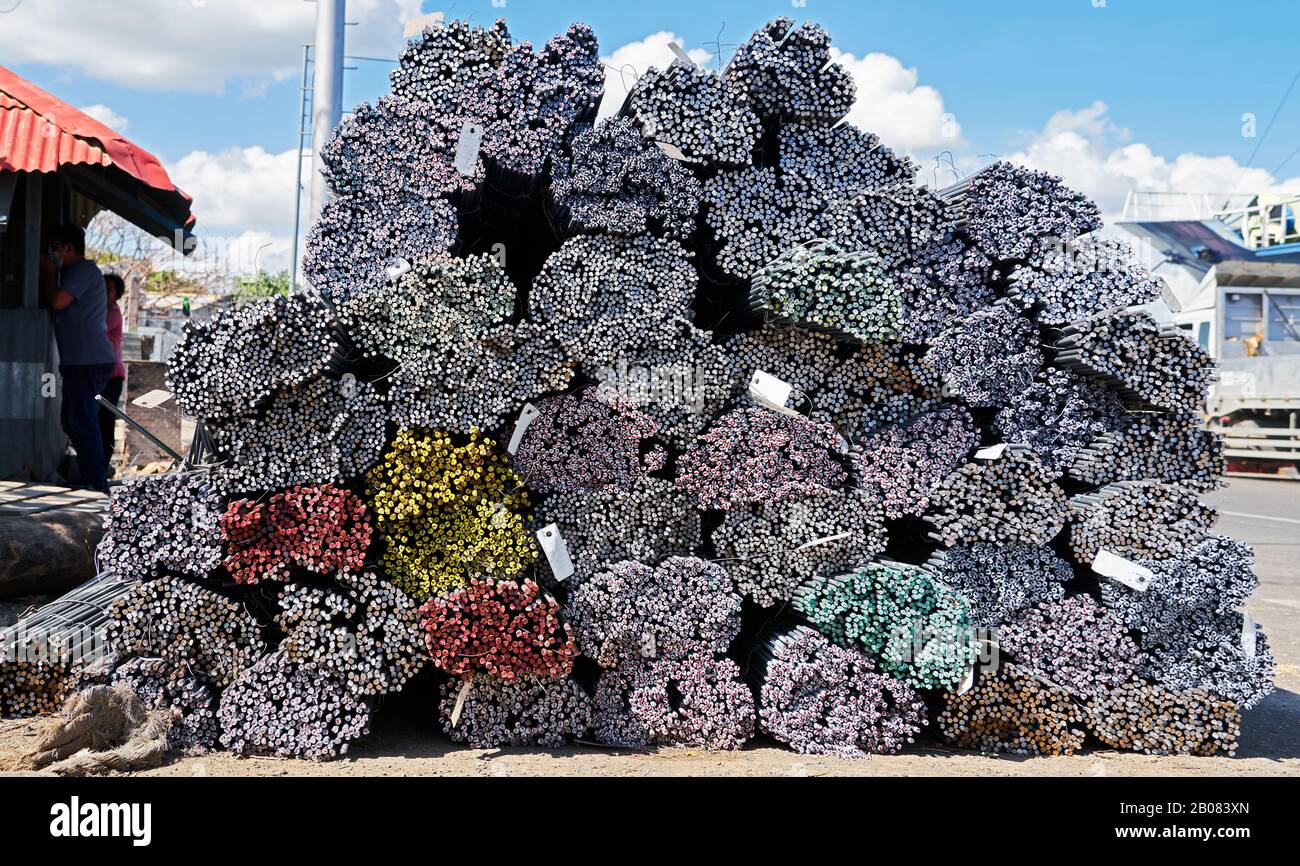 Primo piano di pile di barre d'acciaio, segnate alla sua estremità con colori diversi per una più facile identificazione, visto nell'area portuale di Iloilo City, Filippine Foto Stock