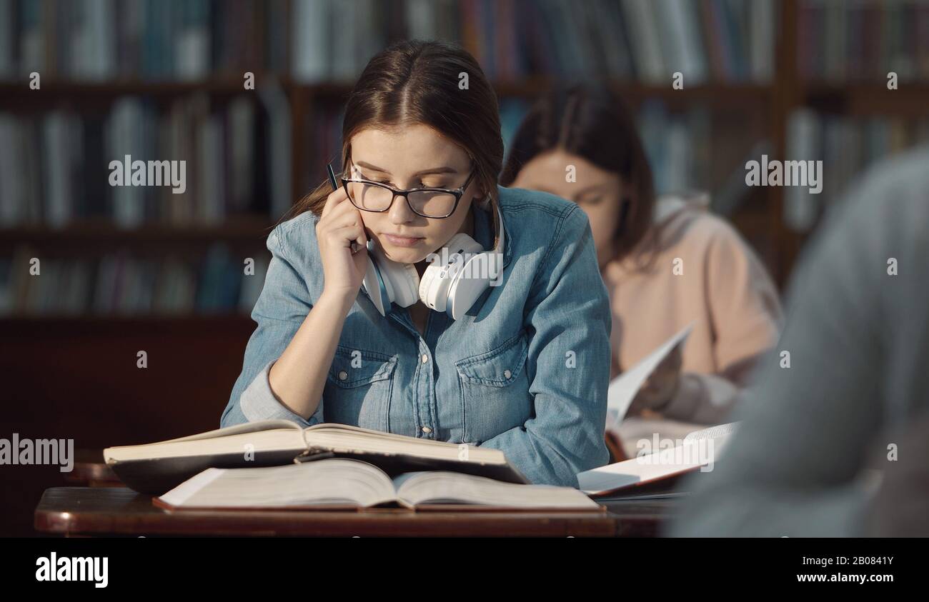 Studentessa studiare in biblioteca Foto Stock